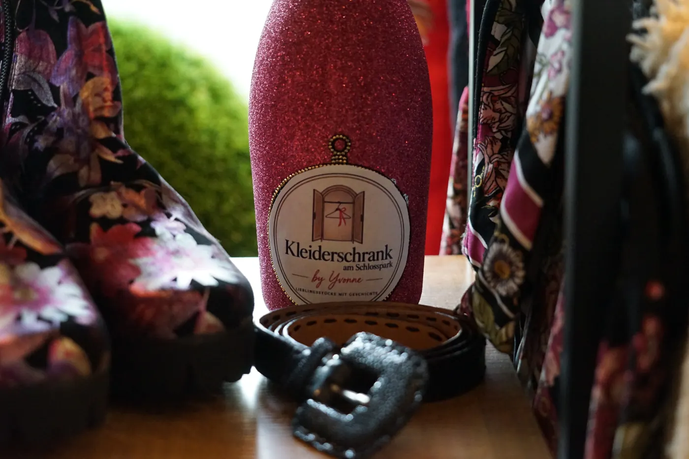 Tücher und Gürtel neben der Kleiderschrank-Flasche